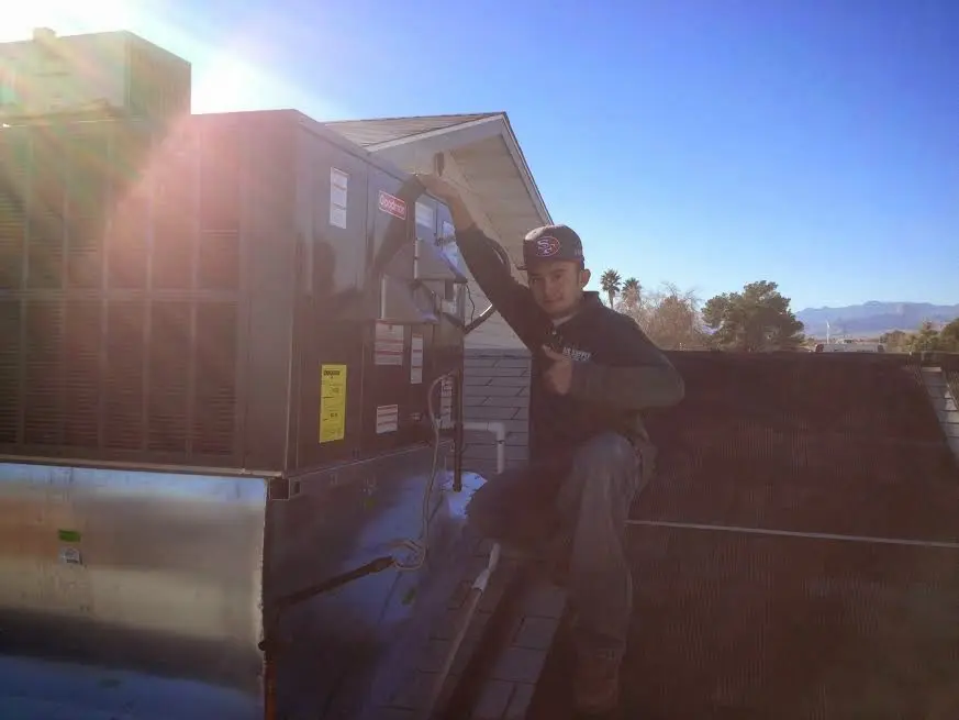 HVAC technician performing Air Duct Cleaning on a rooftop unit in Leesville